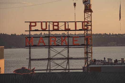 View of the famous Pike Place Market sign in Seattle during a vibrant sunset.