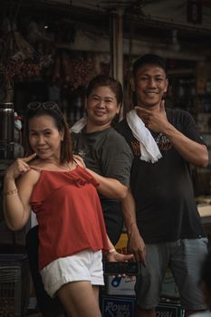 Three friends posing playfully in an urban street setting, showcasing warmth and camaraderie.