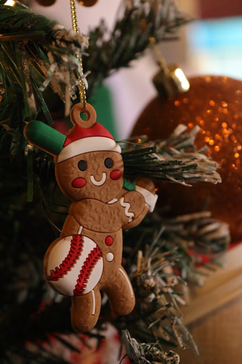 A gingerbread man ornament hanging from a christmas tree