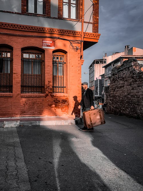Man Carrying Suitcase on Street in Town in Turkey