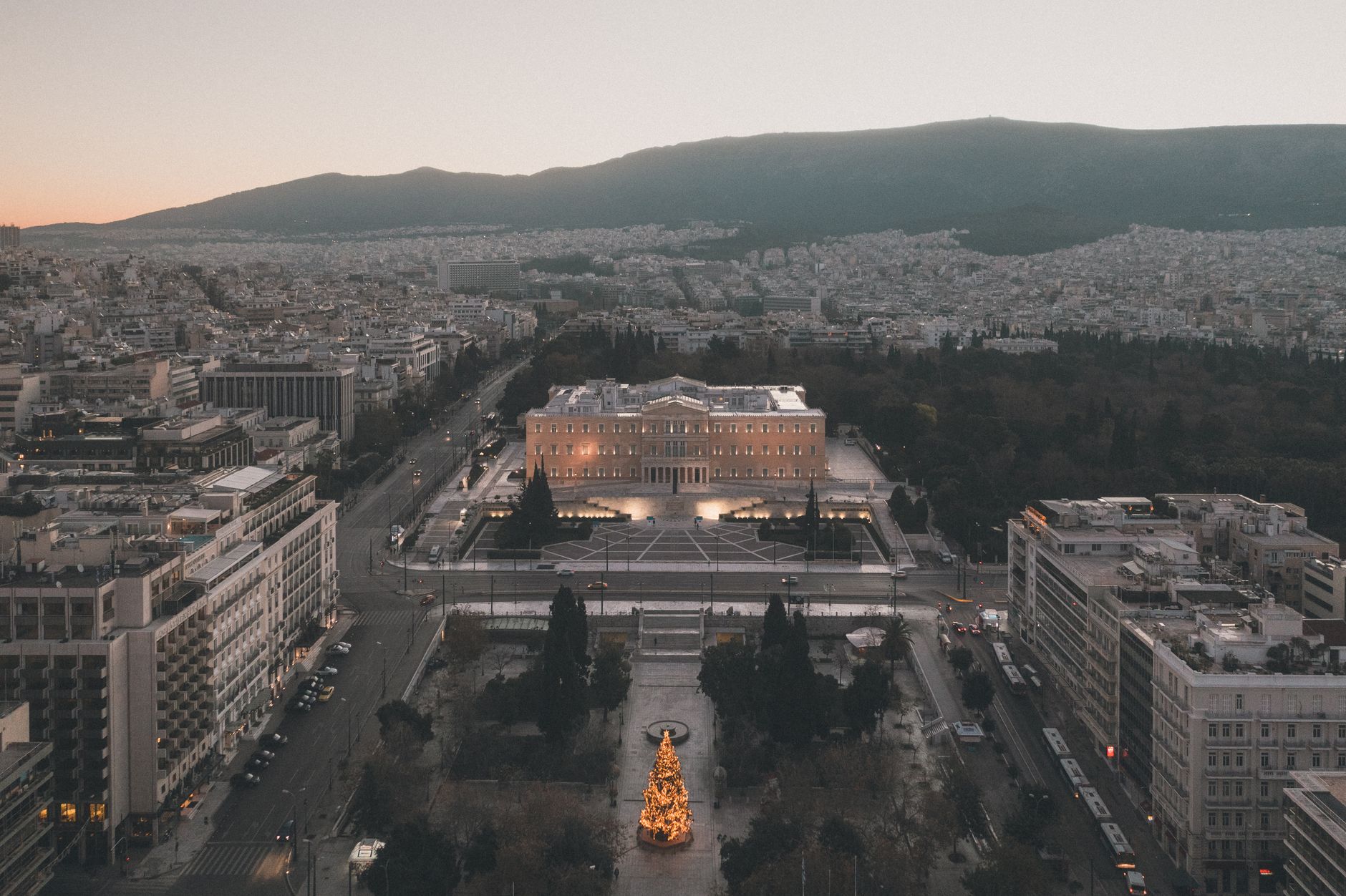 Scenic aerial view of Syntagma Square, Athens, Greece, illuminated at dusk with a Christmas tree.