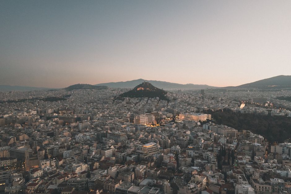 Stunning aerial view of Athens' cityscape with horizon at twilight.