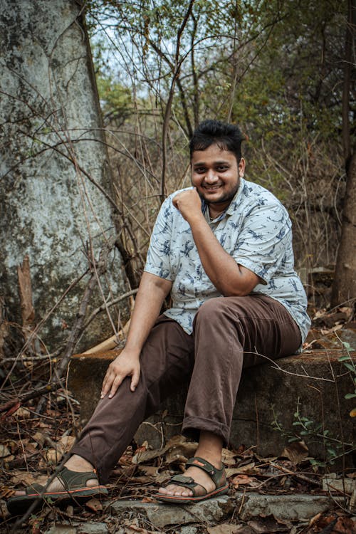 Man Smiling and Sitting in Forest