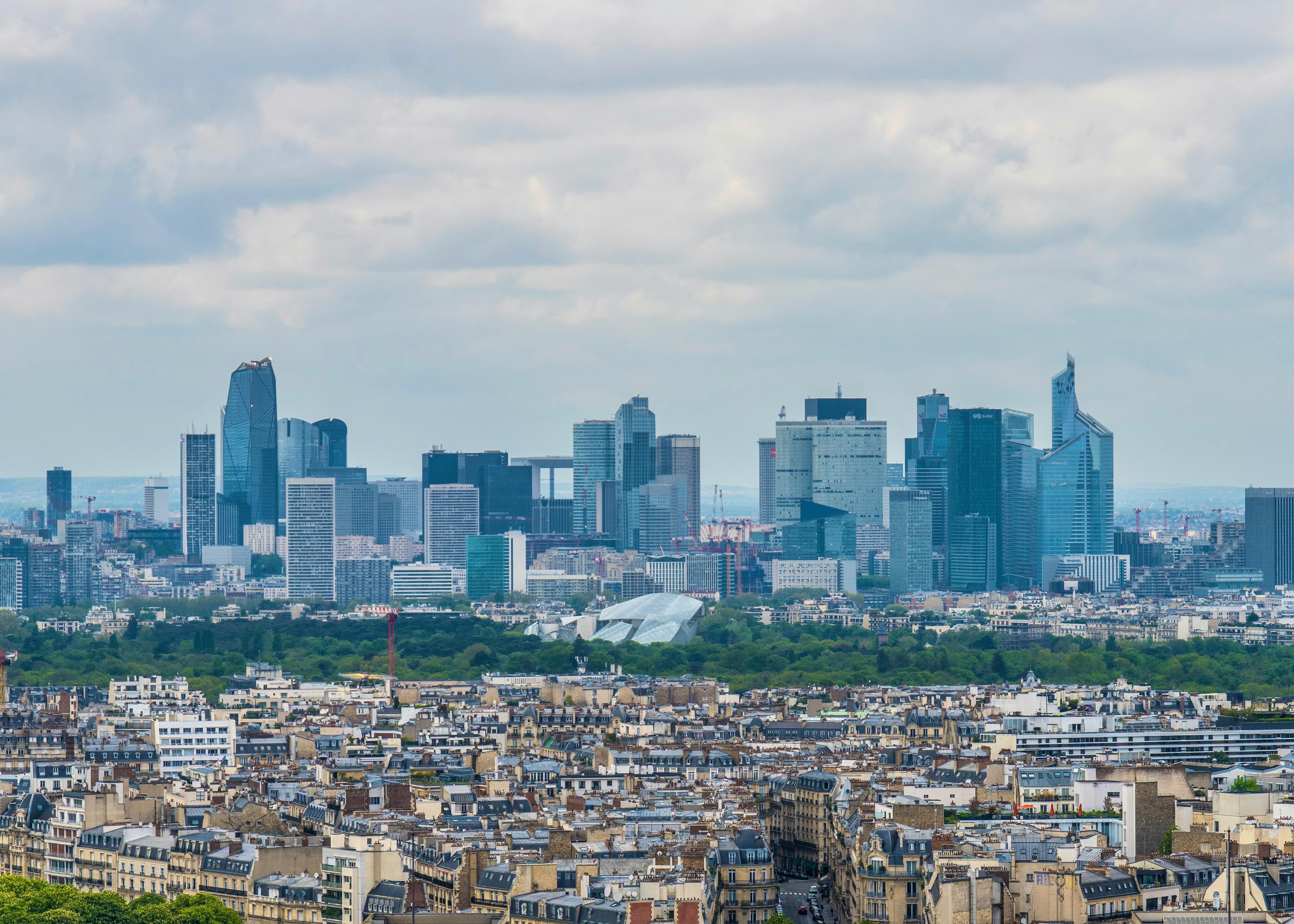 Paris'te modern bir ofis ortamında iş görüşmesi yapan profesyoneller ve arka planda Eyfel Kulesi manzarası.