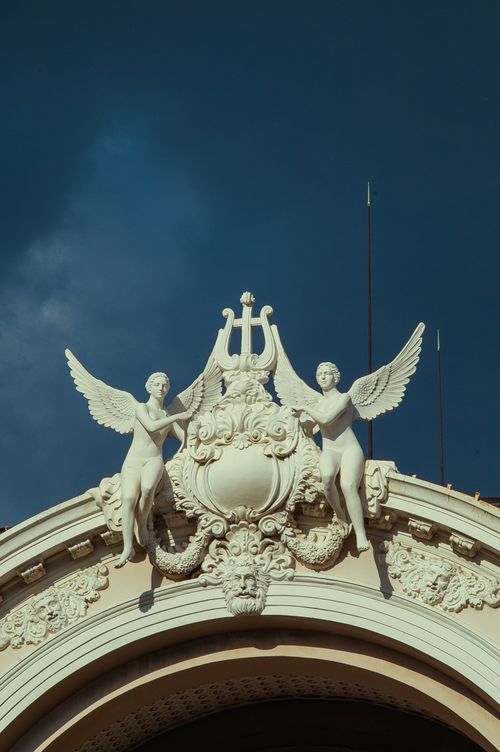 Free Detailed view of angel sculptures adorning the Ho Chi Minh Opera House against a clear sky. Stock Photo