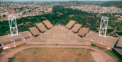 Free Drone shot of the empty Mmabatho Stadium in Mafikeng, surrounded by urban landscape. Stock Photo
