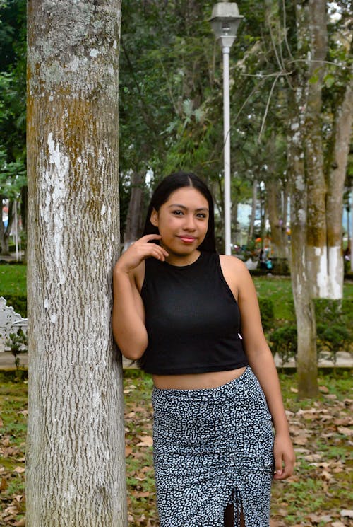 Smiling Woman Standing by Tree in Park