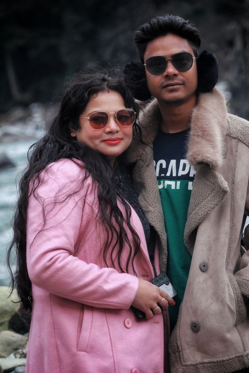 Free A fashionable couple wearing coats and sunglasses poses confidently outdoors in winter. Stock Photo