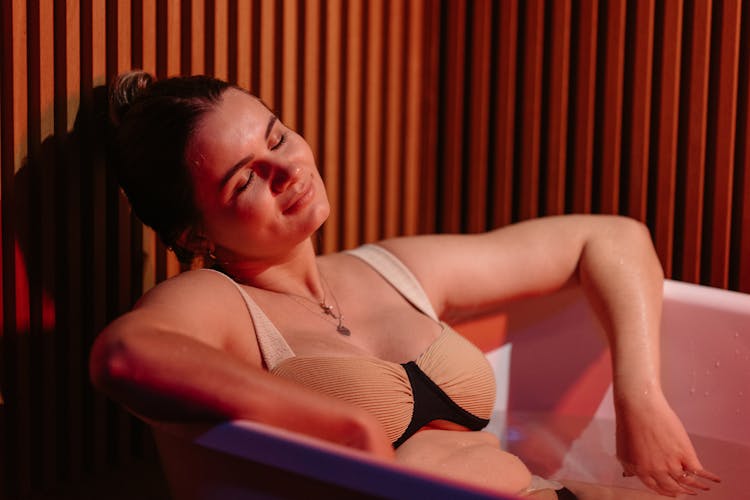 Woman Relaxing In Bathtub Filled With Water