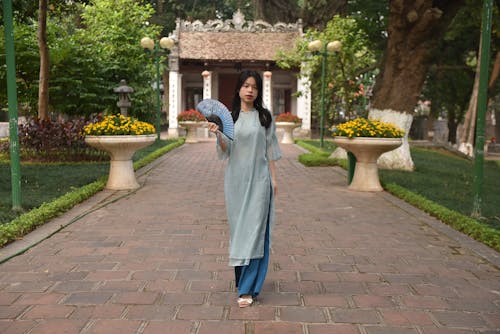 A Young Woman with a Fan in a Garden