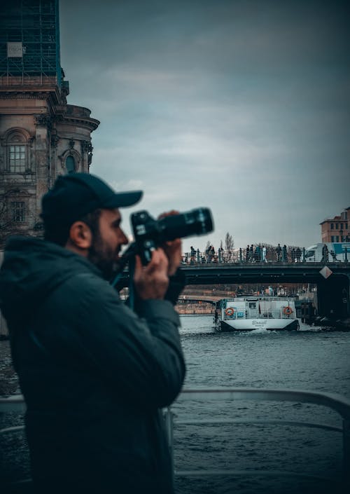 Man Taking Pictures by River in Berlin