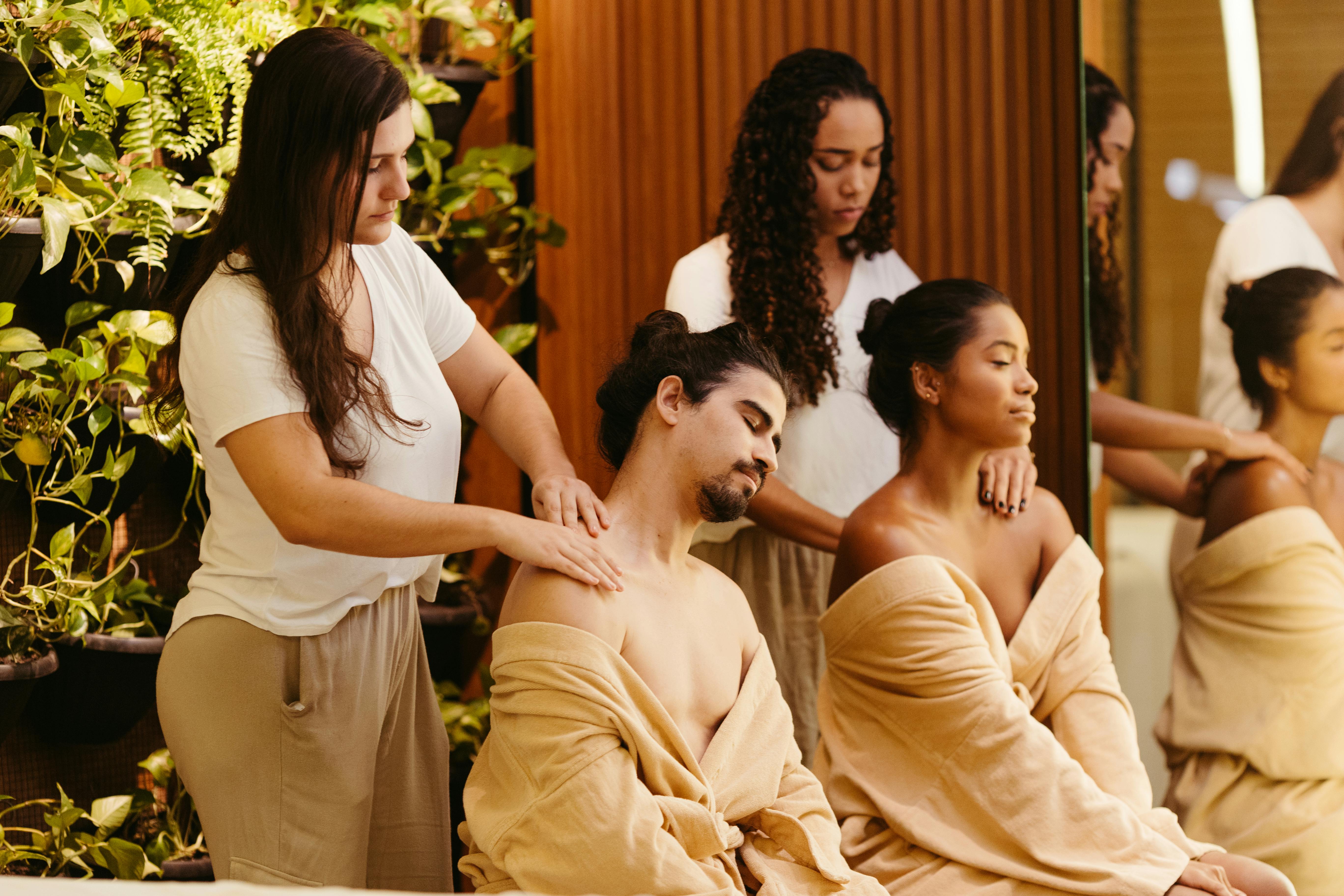 Free Two clients enjoy a relaxing massage from professional therapists in a spa setting, promoting wellness and relaxation. Stock Photo