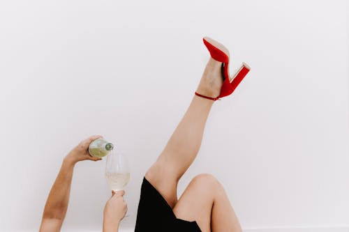 Woman Lying Down with Leg Raised and Pouring Drink