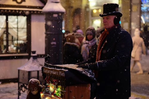 A man in top hat and top hat playing a piano in the snow