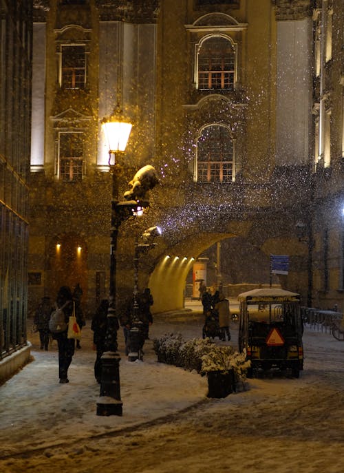 A street lamp is lit up in the snow