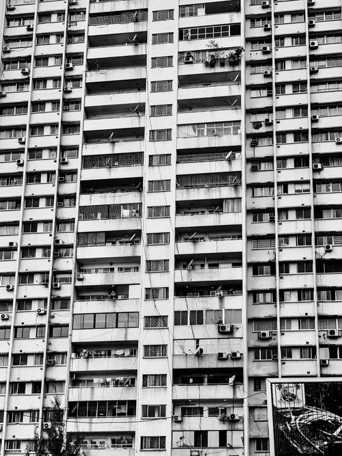 Free Black and white photo of a brutalist high-rise building facade with balconies. Stock Photo
