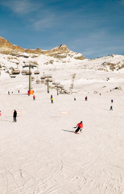 Scenic view of skiers on snowy slopes in Breuil-Cervinia, Italy. Ideal for winter sports enthusiasts.