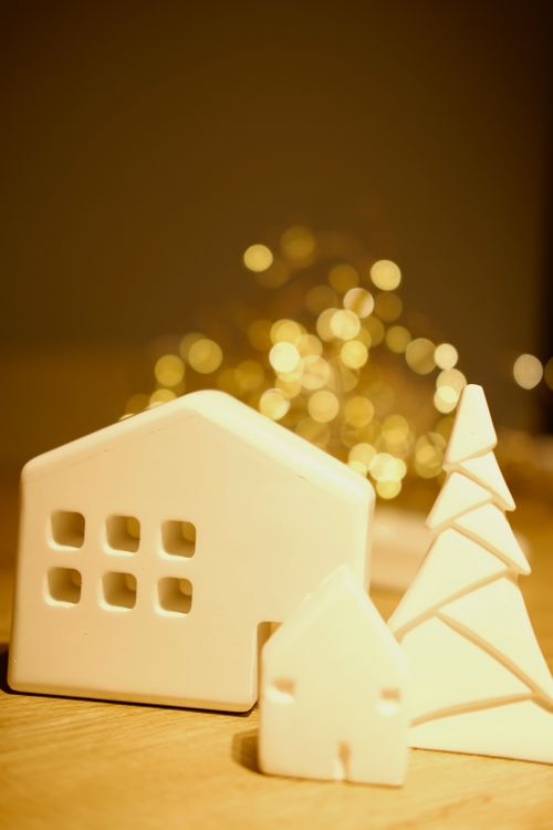 Free Elegant minimalist Christmas setup with ceramic houses and lights for festive decoration. Stock Photo