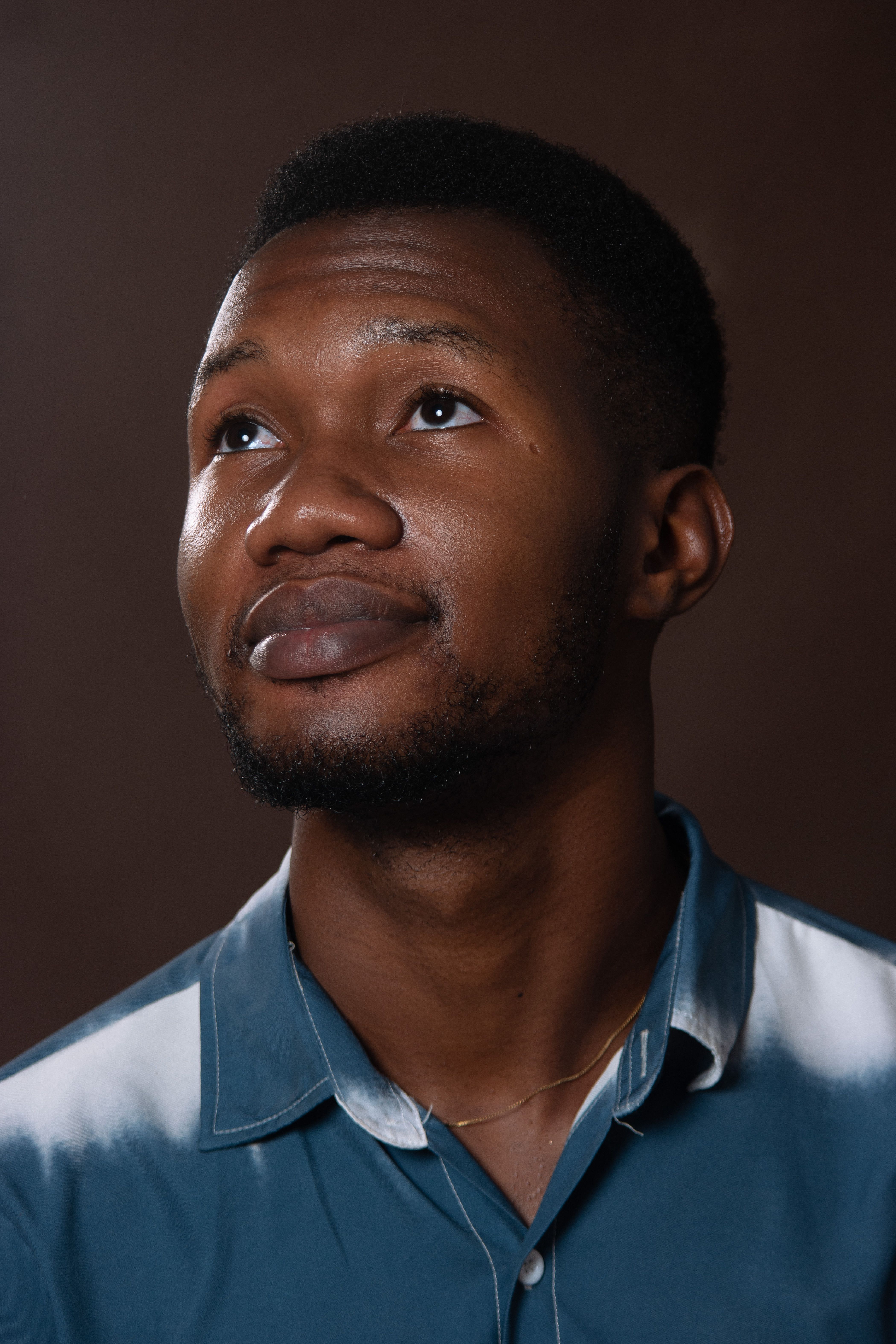 Portrait of a thoughtful man in studio, wearing a polo shirt and looking upward.