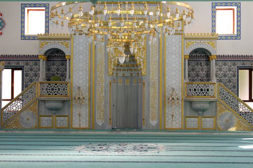 Free Intricate mosque interior with gold chandelier and Islamic art elements. Stock Photo