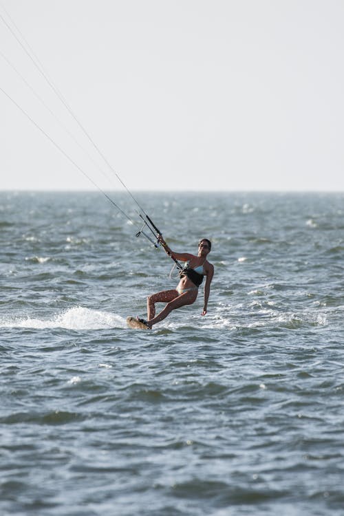Woman in a Blue Bikini Kite Surfing