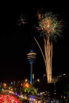 Vibrant fireworks lighting the night sky over Kuala Lumpur's iconic tower, perfect for celebrations.