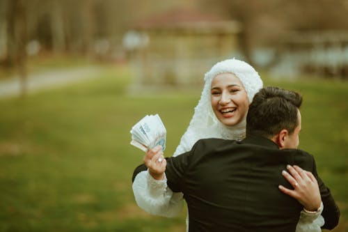 Smiling Newlyweds Hugging and Holding Money