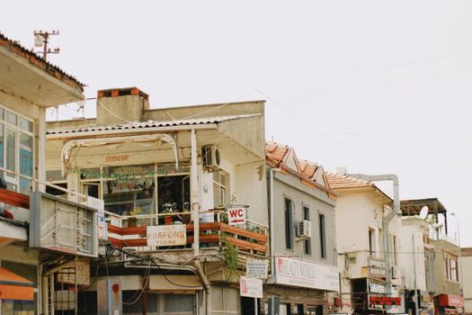 View of an urban street with vintage buildings, balconies, and local shops, creating a charming atmosphere.