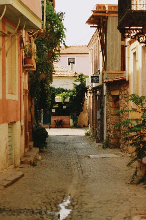 Free A tranquil narrow alley with cobblestone path surrounded by picturesque old buildings. Stock Photo