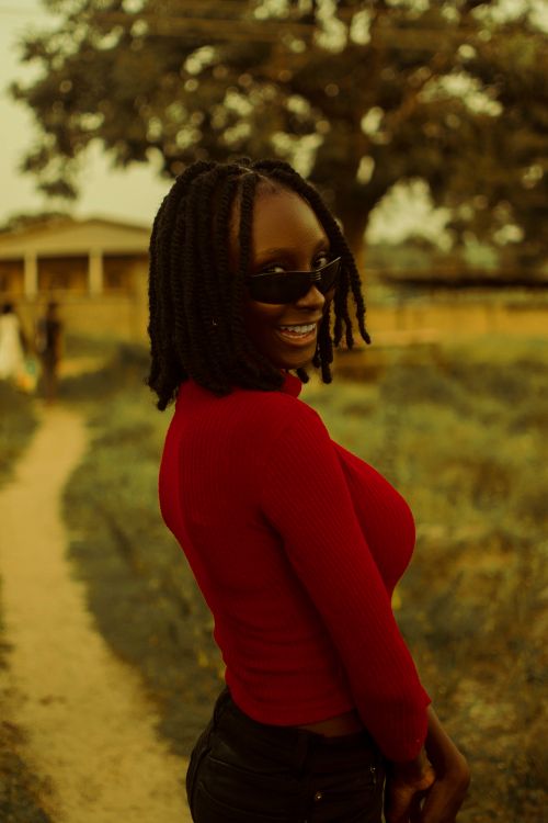 Free Captivating portrait of a cheerful woman with dreadlocks posing outdoors in rural Keffi, Nigeria. Stock Photo