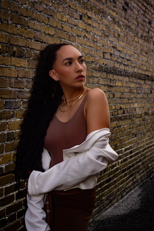 Brunette Posing in front of Brick Wall