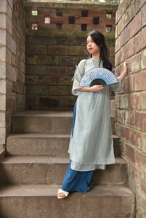 Young Model in Blue Ao Dai Dress Posing on Stairs