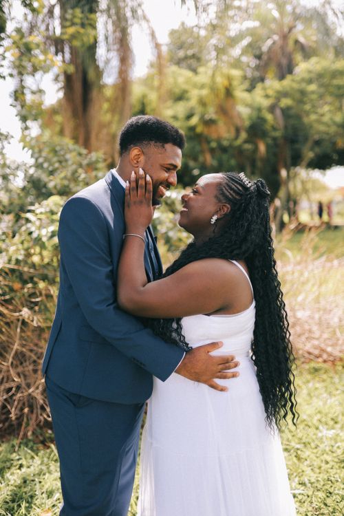 Free Happy newlywed couple embracing in a lush park setting, celebrating their special day. Stock Photo