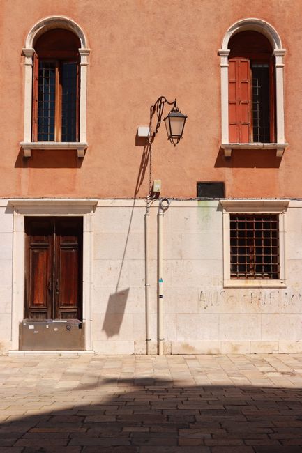 Charming sunlit building facade in Venice, showcasing traditional architecture.