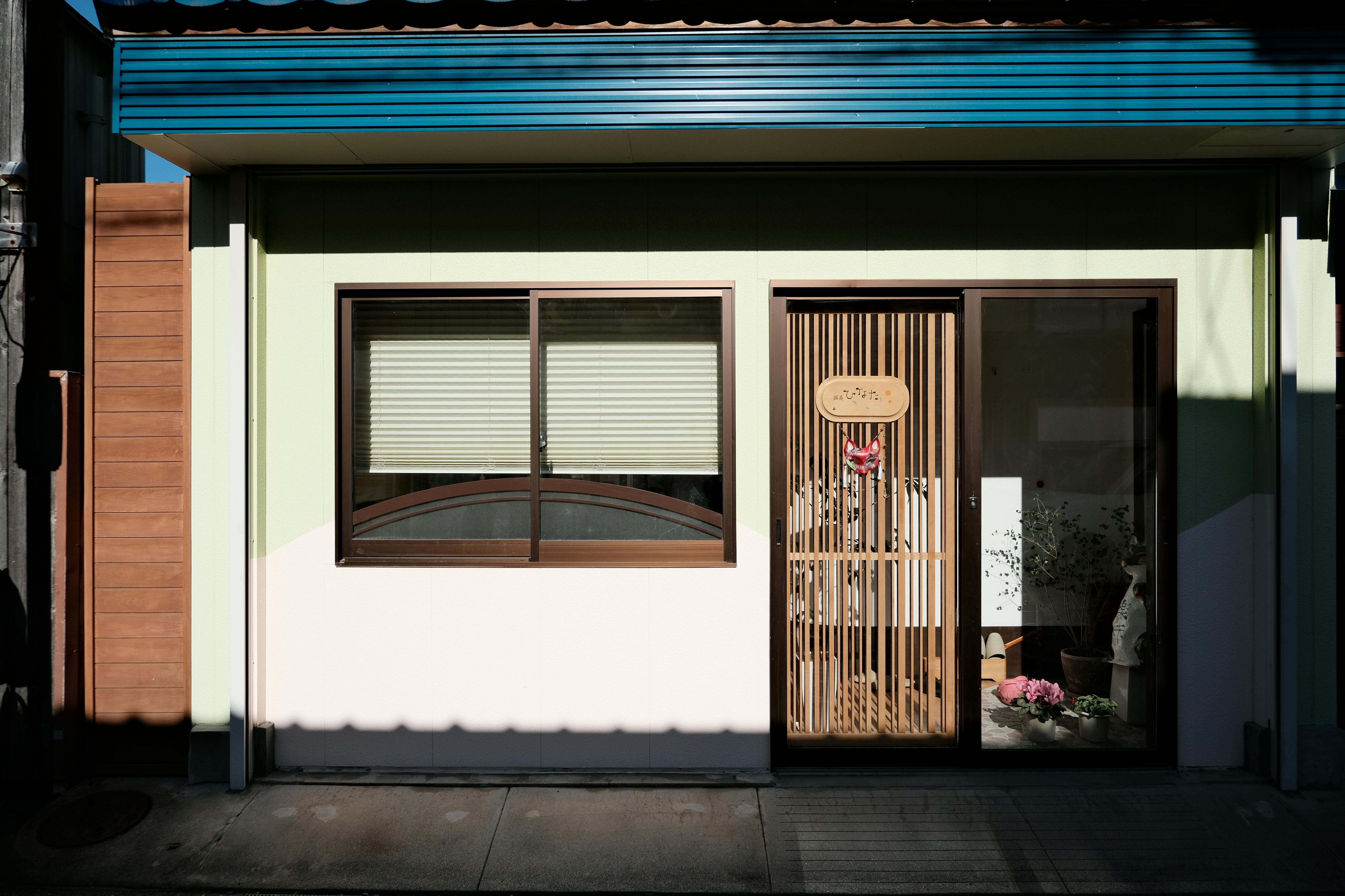 A detailed view of a residential facade with window and door in Toyokawa, Japan.
