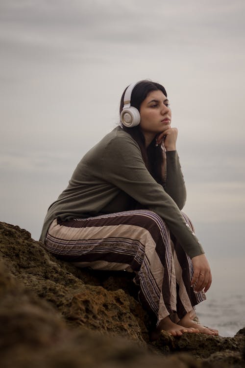 Young Woman Listening to Music on Seashore