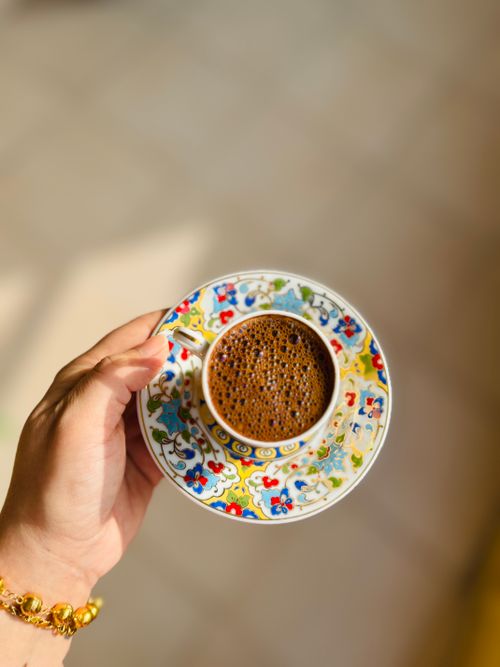 Free A colorful coffee cup held by a hand with intricate design, perfect for lifestyle imagery. Stock Photo