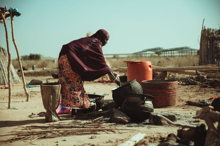 Woman Cooking In A Pot Outside