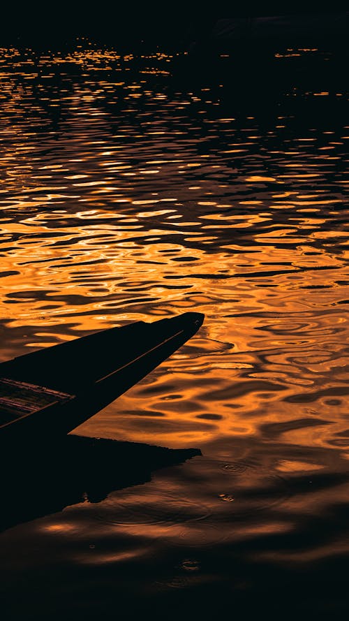 Close-up of a Silhouetted Boat on a Body of Water at Sunset