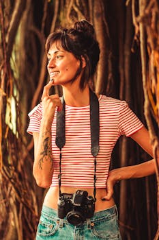 一位女士手持数码单反相机，在郁郁葱葱的热带环境中微笑，非常适合旅行和生活方式主题