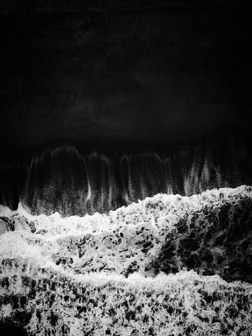 Free Black and white aerial shot of waves crashing on the shore in Terengganu, Malaysia. Stock Photo