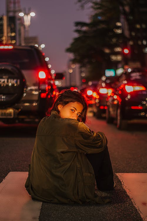 夜の間に道路に座っている女性