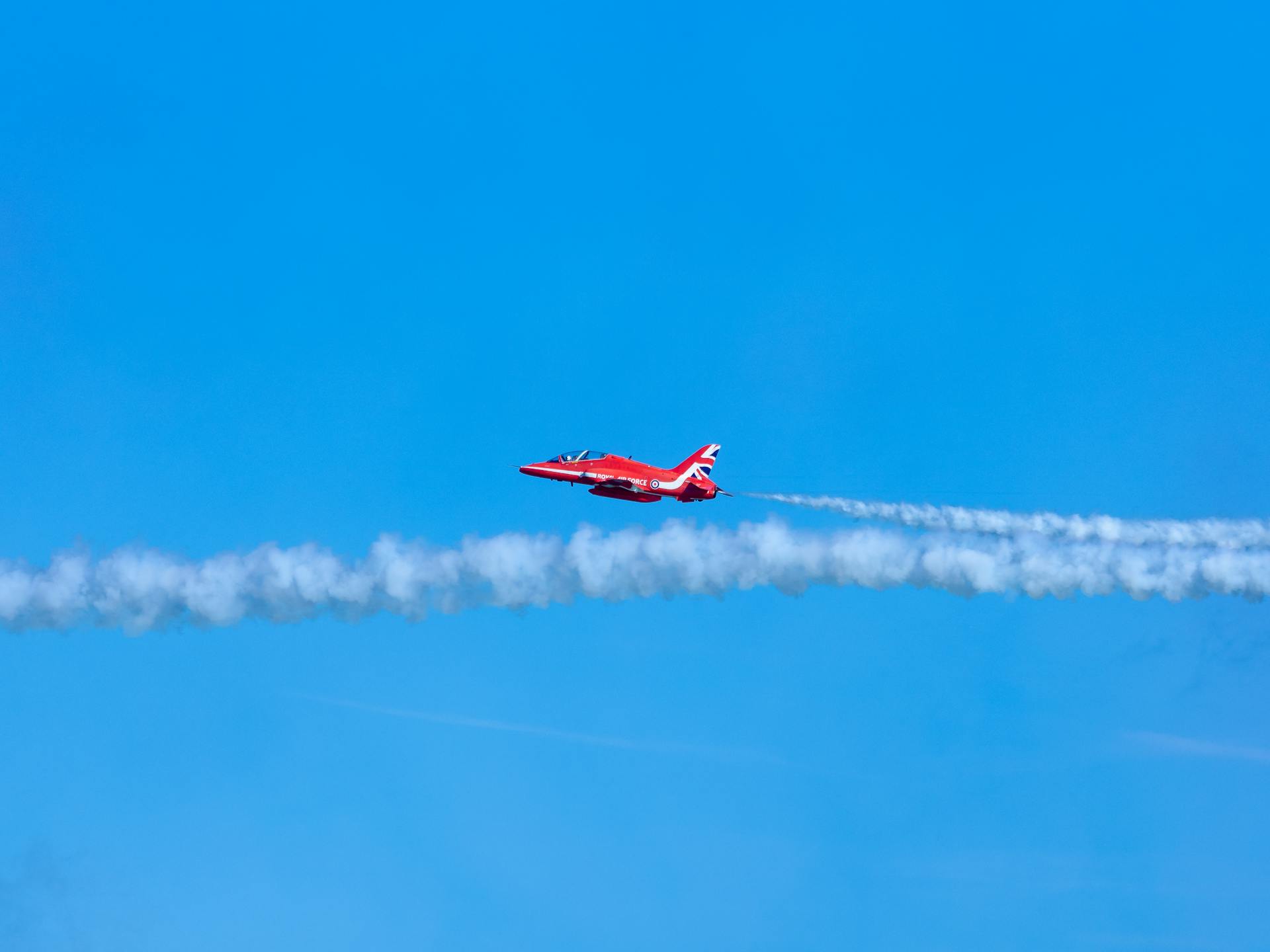 A Hawk T.1 Red Arrows Aerobatic Team Airplane Flying against Blue Sky