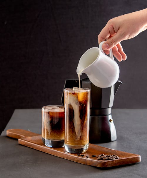 Free Close-up of a Person Pouring Milk into Coffee  Stock Photo