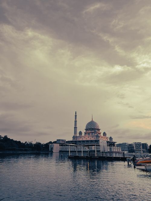 Free Breathtaking view of the iconic Putra Mosque by the waterfront in Putrajaya, Malaysia during an overcast day. Stock Photo