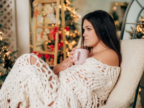 Woman Sitting Under Blanket with Coffee