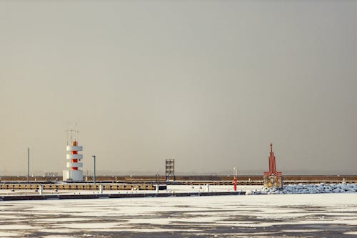 View of a Pier and Snowy Seashore 