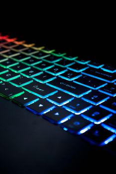 Close-up of a colorful illuminated RGB keyboard with vibrant lights.