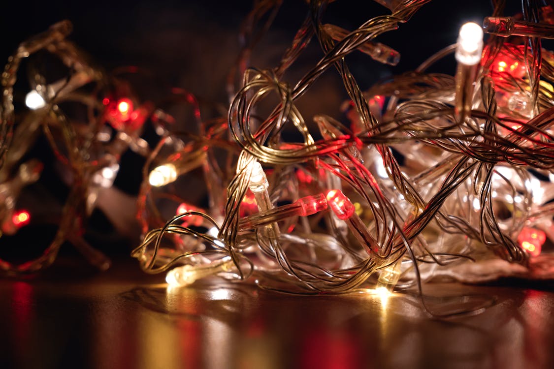 Free Close-up of entangled colorful LED string lights on a dark background. Stock Photo