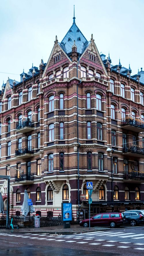 Free Gothic-style brick building on a street corner in Gothenburg, Sweden, showcasing intricate facades. Stock Photo